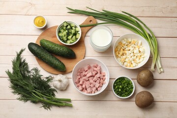 Fresh ingredients for okroshka soup on light wooden table, flat lay