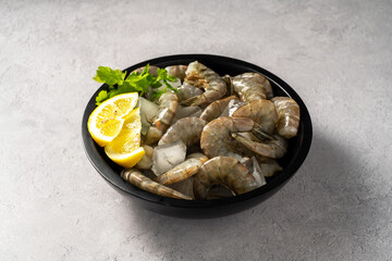 Raw Shrimps prawns and ice cubes with lemons