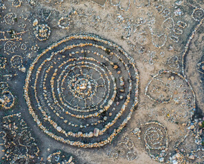 Aerial view of human made stone circle patterns of land art in coastal area in Sardinia.