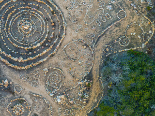 Aerial view of human made stone circle patterns of land art in coastal area in Sardinia.
