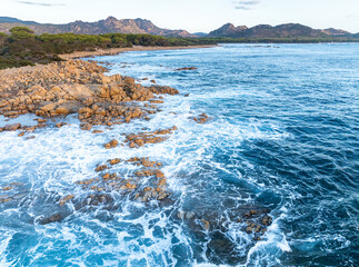 Aerial view of coast in Sardinia, Italy. Beach along coastline in Mediterranean Sea with waves and turquoise water.