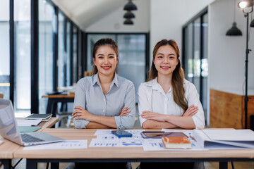 Entrepreneur Happy Asian business two women discussing new business project in tablet in modern Meeting In Modern Office, Asian business casual concept.
