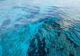 Aerial view of shallow turquoise ocean water with seafloor underneath. Overhead view of mediterran sea.