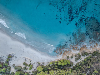 Aerial view ocean waves on remote and wild sandy beach in Italy. Background texture of water, waves and beach.