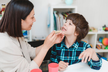Cute preschool child is engaged in speech therapist office and correcting his speech