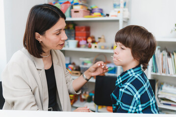 Cute preschool child is engaged in speech therapist office and correcting his speech