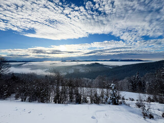 Serene snow-covered landscape under a vibrant sky with scattered clouds