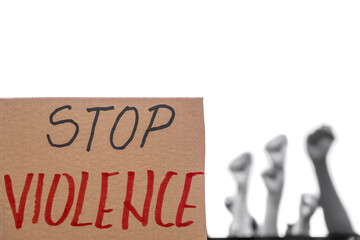 cardboard sign with words Stop Violence with protestors raising fists in the blurred background