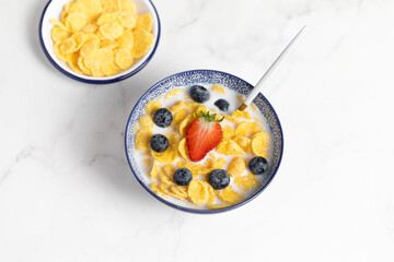 cornflakes  in a bowl on a light background, breakfast