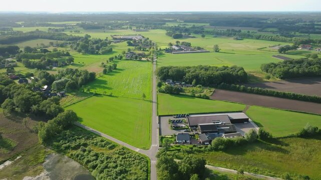 Aerial typical Dutch countryside with green fields, rural roads, and scattered farm buildings in sunny landscape