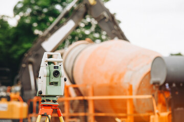 Construction site with surveying equipment and a concrete mixer