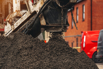 Construction site activity involving aggregate and concrete delivery and preparation in a residential area