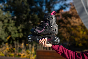 Woman holding inline skates in a park