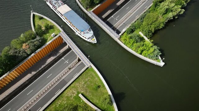 Aerial footage of a tourist ferry passing the aqueduct Veluwemeer above the highway. View of water bridge Aquaduct Veluwemeer allowing vehicular and waterborne traffic to pass over or under one anothe