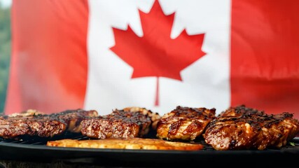 Grilled meat on a barbecue with a Canadian flag in the background. The video captures a patriotic celebration or outdoor event. Ideal for national or festive themes