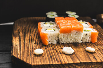 Variety of Sushi Rolls with Chopsticks on Black Board
