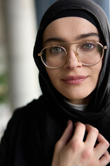 A stunning Muslim businesswoman is captured in a close-up portrait, showcasing her captivating green eyes behind stylish prescription glasses, radiating elegance and confidence