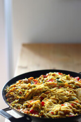 Bowl of stir fry vegetables and noodles, served on the table. Selective focus.