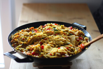 Bowl of stir fry vegetables and noodles, served on the table. Selective focus.