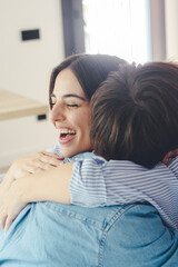 Naklejka premium Beautiful young couple hugging in their new apartment. Engaged couples celebrate by hugging each other happily for their new home.