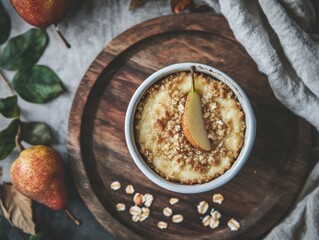 A cozy autumn spiced pear crumble with oats and almonds, served in a small ramekin on a rustic wooden tray