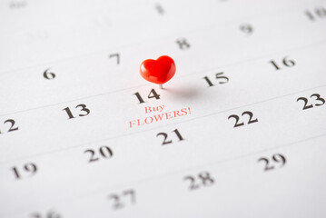 Calendar with a red heart pin emphasizing the romantic date of February 14 for plans