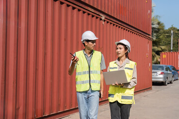 Construction team discussing logistics and project plans outdoors near shipping containers