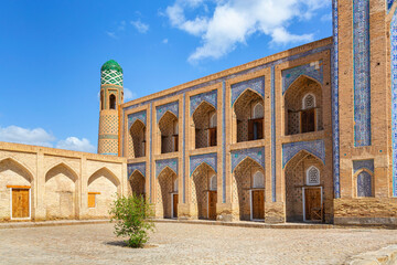 Facade of Mukhammad Rakhim Khan madrasa, showcasing intricate tilework, arched windows, and a...