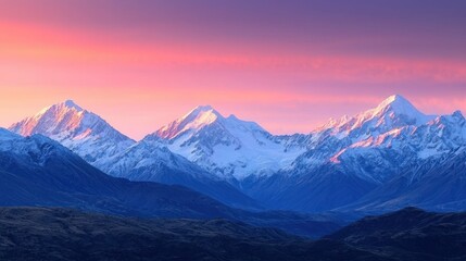 Fototapeta premium A vast mountain range with snow-capped peaks under a glowing sunrise, evoking a sense of natural wonder