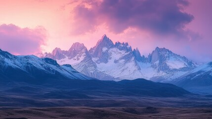 Fototapeta premium A vast mountain range with snow-capped peaks under a glowing sunrise, evoking a sense of natural wonder