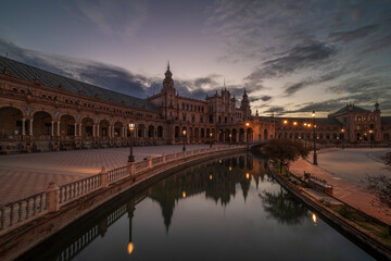 Naklejka premium Plaza de Espana, Seville, Andalusia, Spain, at sunrise. The building is reflecting in the calm, smooth water.