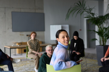 Obraz premium A diverse group of business professionals sits attentively in a modern office, actively participating in a training session led by an instructor, focusing on the latest technological advancements in