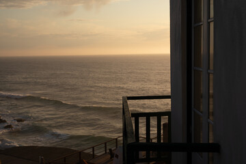 A glimpse of the ocean through a window at sunset