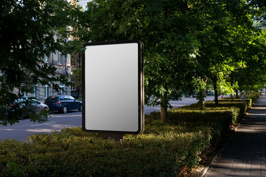 An outdoor billboard mockup in a old town park environment. Isolated blank surface to place your design.