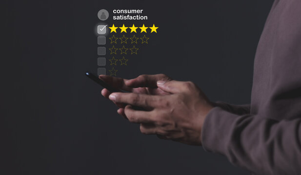 Consumer Satisfaction; Young Man hand holding Smart Phone with five star to review and give 5 stars with very good results in service, Good review 5 star rating choice feedback