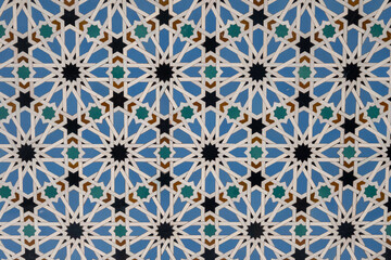 Ornamental colourful geometric medieval ceramic tiles of walls in old castle, Sevilla or Granada, Andalusia, Spain. Arabic ornament background wallpaper