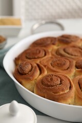Tasty cinnamon rolls on white table, closeup