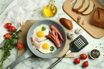 Tasty brunch. Fried eggs, sausages, bacon and other products on white marble table, flat lay