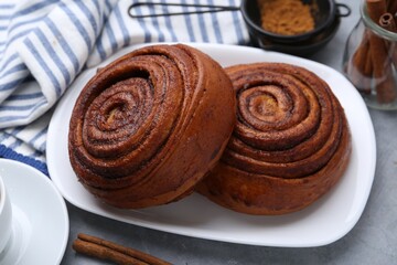 Delicious cinnamon rolls on grey table, closeup