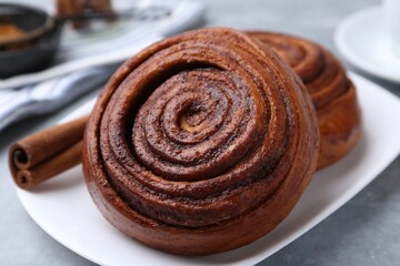 Fototapeta premium Delicious cinnamon rolls on grey table, closeup