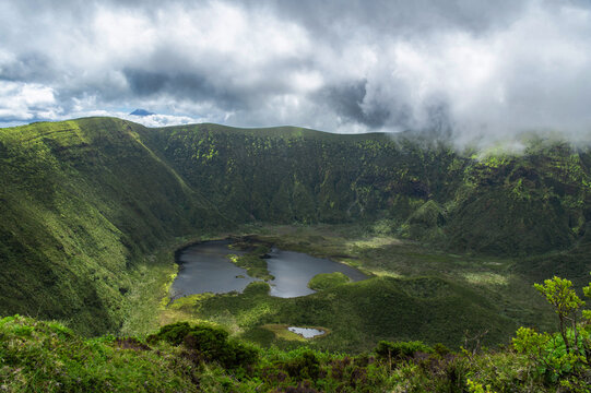 Crater of Vulc&atilde;o da Caldeira or The Caldeira Volcano on Faial Island, the Azores, in the Atlantic Ocean. Stratovolcano with a lake inside the crater. Low clouds. Hiking around volcano.