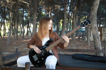 Girl Plays The Bass Instrument In The Countryside In Summer
