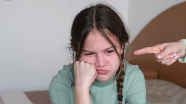 Little girl crying with resentment while parents scolding her at home. Kid having bad mood and feeling upset. Family punishment concept