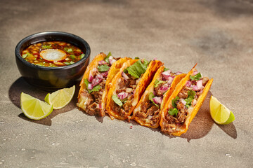 Traditional mexican birria consome soup and four taco with stewed beef