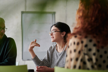 A diverse multiethnic business team engages in a collaborative meeting, discussing strategies and...