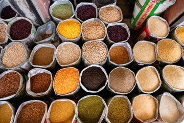 Verschiedenste Gewürze, Körner, Bohnen und Zutaten auf einem Markt im Säcken in der Stadt Jaipur in Indien
