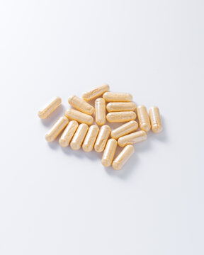 orange capsules with vitamins on a white background