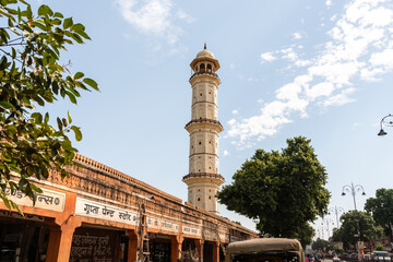 Turm einer religiösen Städte ragt aus den Märkten und ständen in Jaipur in Indien hervor
