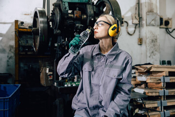tired fatigue exhausted women worker drinking water brake relax at heavy metal factory