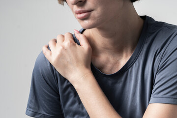 Close-up portrait of young woman suffering from shoulder pain	